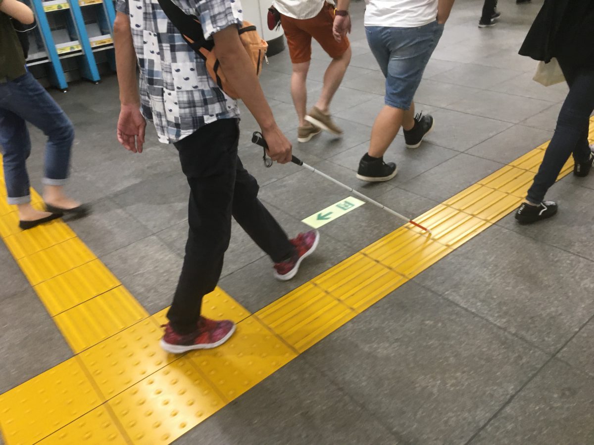 Person walking with white cane