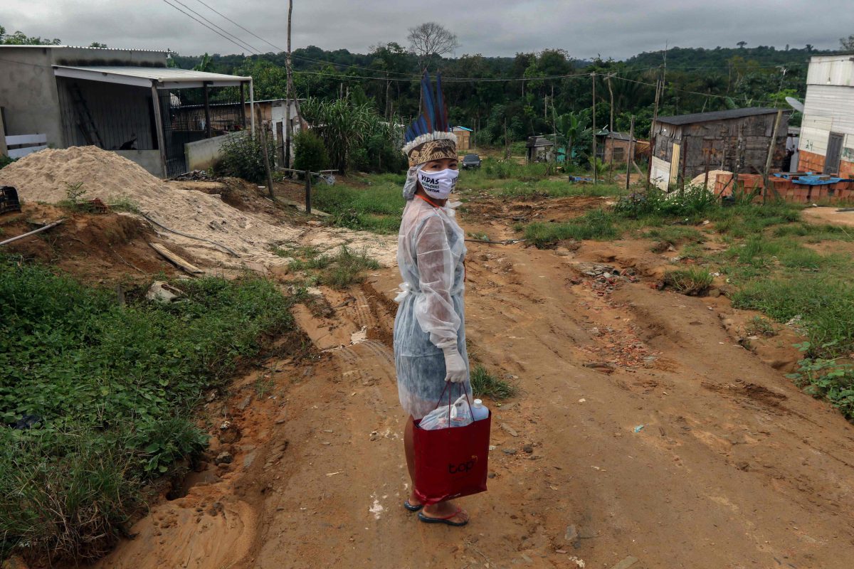 Woman in protective gear walking down dirt road and facing camera