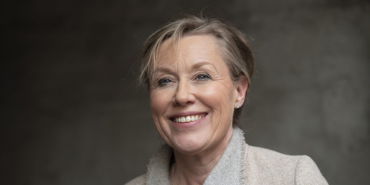 Kvinne står foran en vegg.